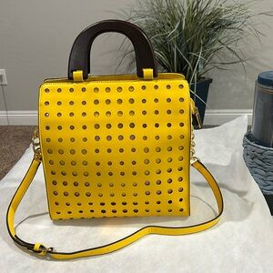 NWOT Yellow vegan leather bag w/circle cut-outs in front & adjustable strap.